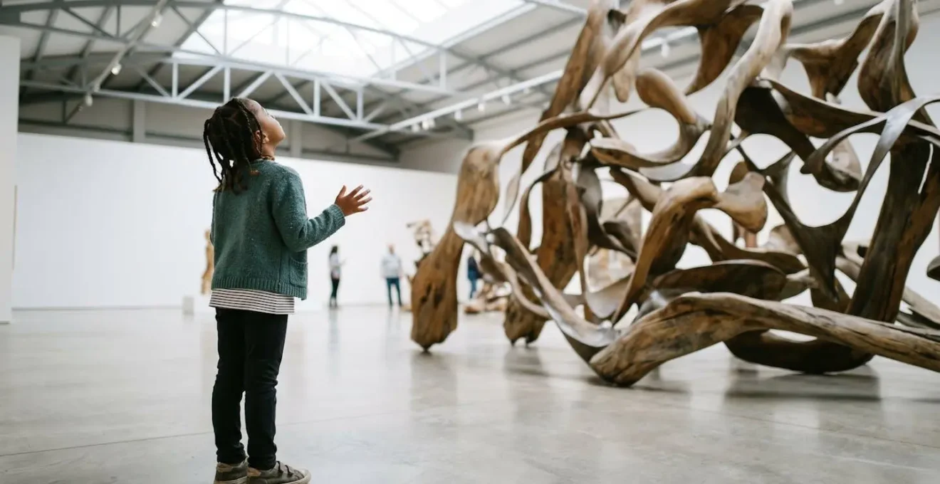 Enfant observant avec curiosité une installation artistique abstraite dans un espace muséal lumineux