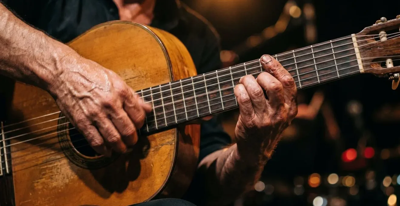 Gros plan sur les mains d'un guitariste flamenco en pleine performance sur une guitare traditionnelle