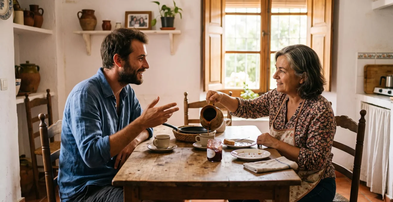 Une voyageuse et son hôte espagnole partagent un café matinal autour de la table d'une maison familiale lumineuse en Espagne.